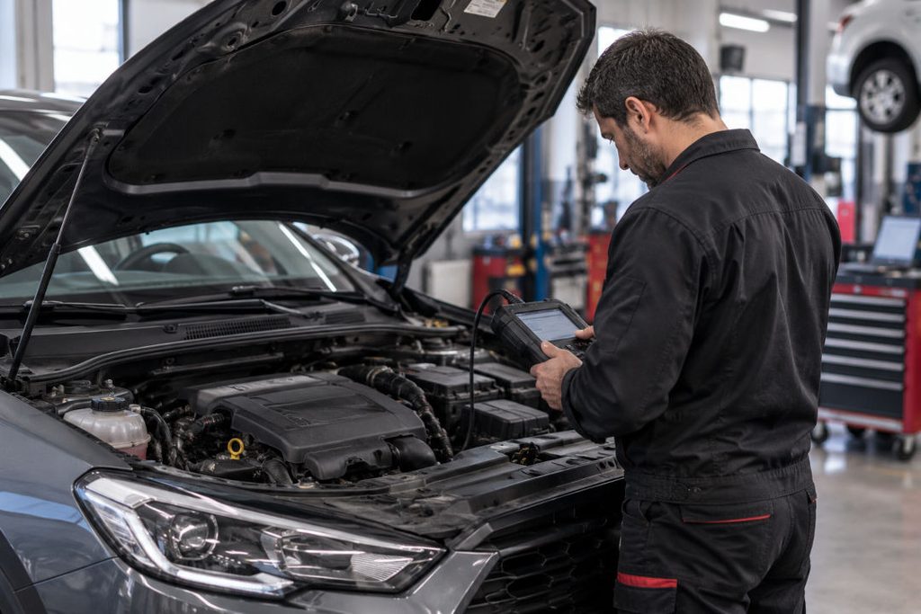 fotografía de un técnico en un taller midiendo el voltaje